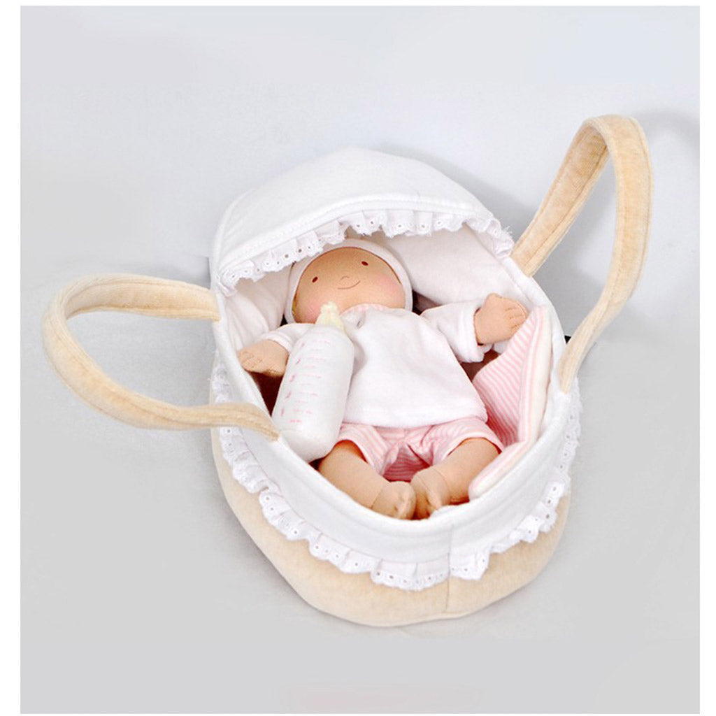 A view of a personalised Bonikka rag doll baby inside of a cot with large carrying loops.  