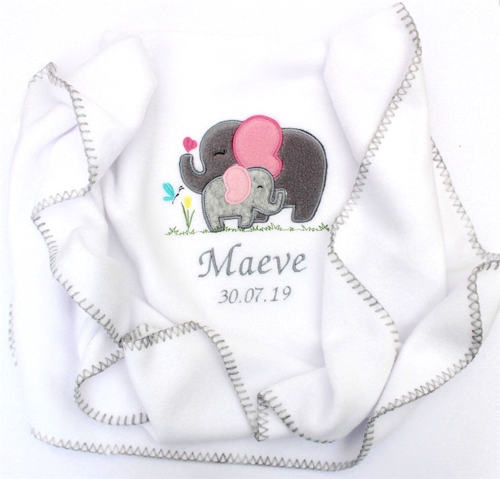 A beautiful white blanket embroidered with a mother elephant and her baby and personalised with name and date