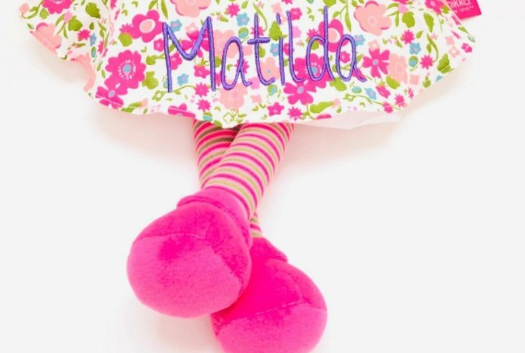 A Katy Rag Doll from Bonikka in a flowery pink dress and pink shoes with a personalisation name