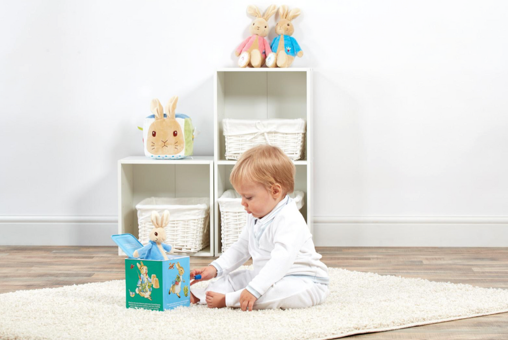 A child playing with a Beatrix Potter Peter Rabbit Jack in the Box toy gift with bunny standing up in box