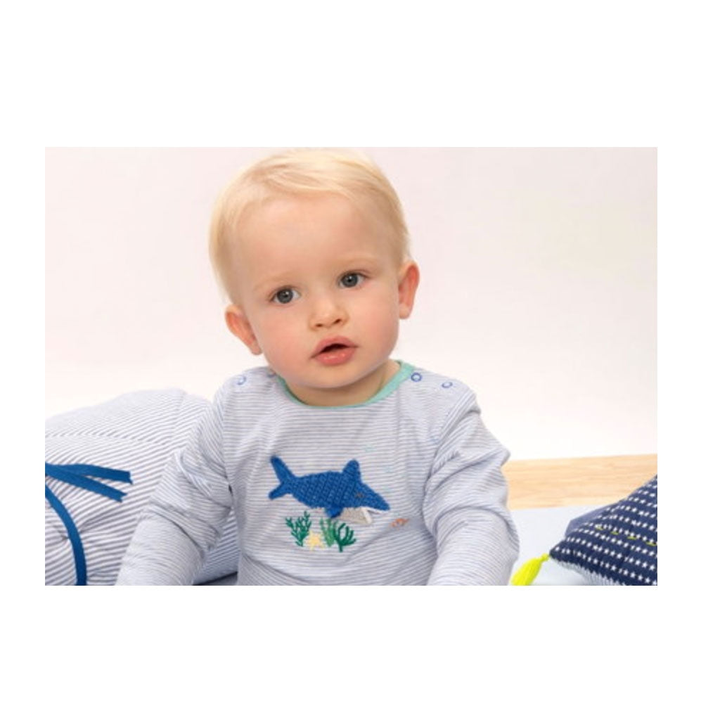 Baby boy wearing a A gorgeous Albetta babygrow featuring a hand crocheted shark on a stylish blue stripe.