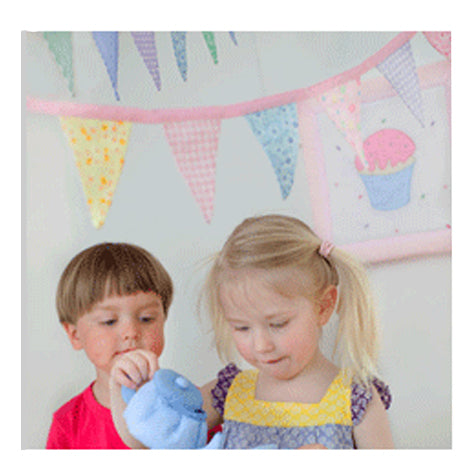 Children playing with a pretty soft fabric bunting in pink.