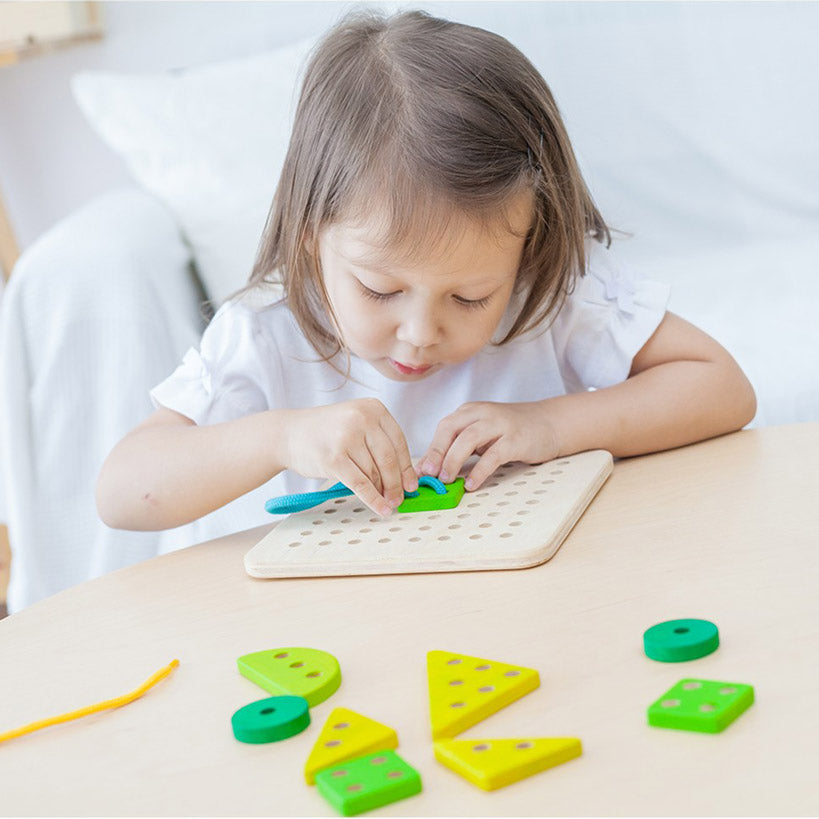 little girl playing with a Plan Toys Eco Friendly Lacing Board